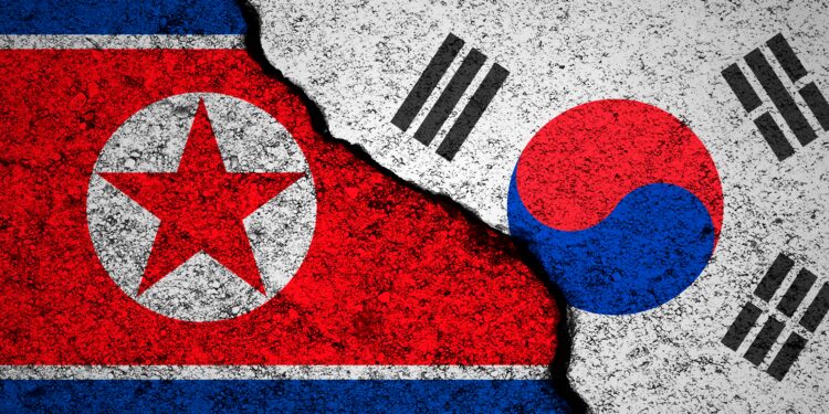 North Korea and South Korea flags background. Cracked wall. Military conflict and war concept