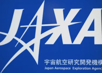 FILE PHOTO: A logo of Japan Aerospace Exploration Agency (JAXA) is seen in front of a gate at the JAXA Chofu Aerospace Center Aerodrome Branch in Tokyo January 22, 2013. REUTERS/Issei Kato