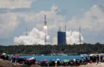 FILE PHOTO: People watch from a beach as the Long March 5 Y-4 rocket, carrying an unmanned Mars probe of the Tianwen-1 mission, takes off from Wenchang Space Launch Center in Wenchang, Hainan province, China July 23, 2020. China Daily via REUTERS