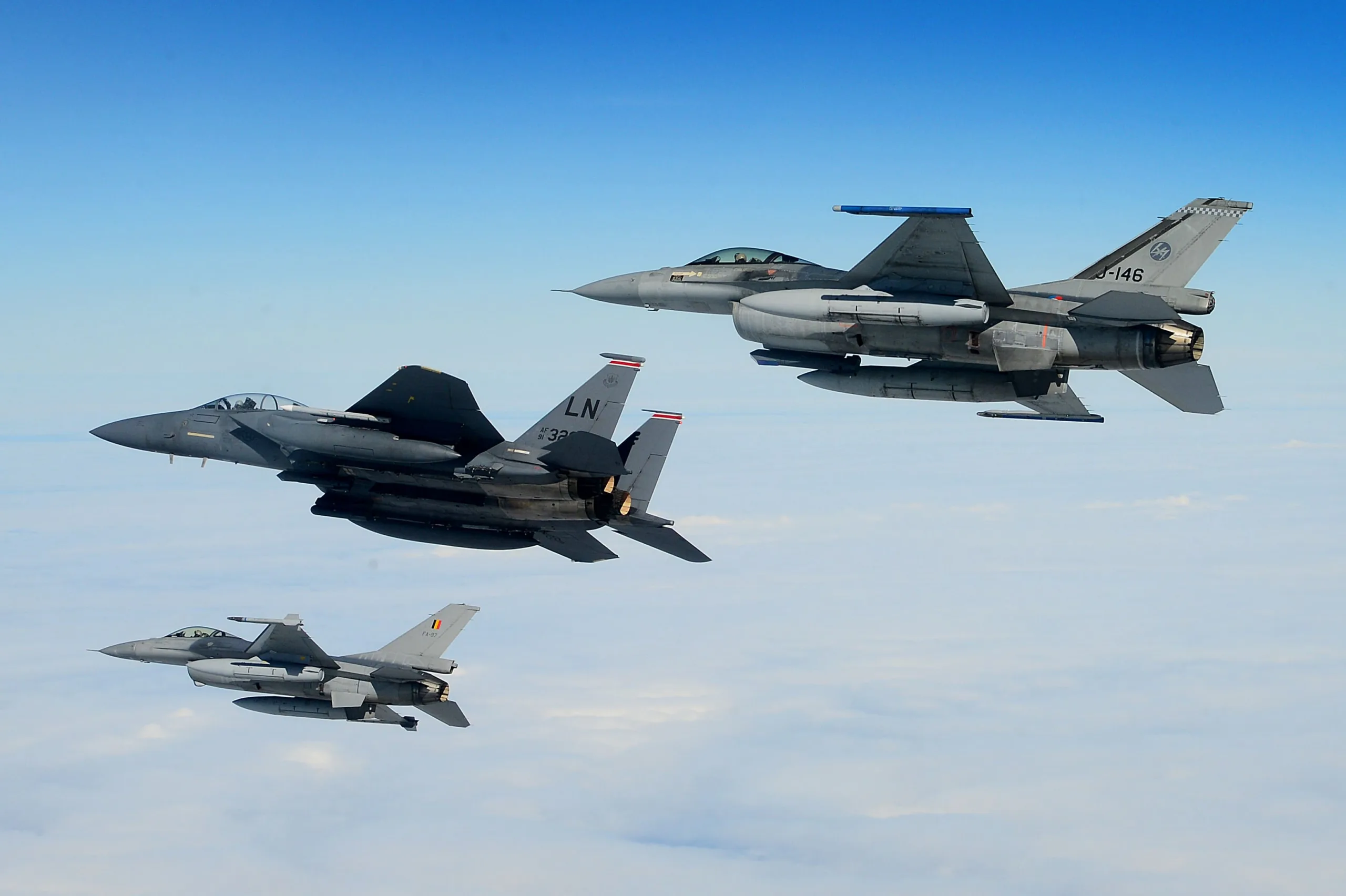 An U.S. Air Force F-15E Strike Eagle, Royal Netherlands Air Force F-16 (top) and Belgian Component F-16 (bottom) conduct aerial operations over the North Sea, July 17, 2020. Interoperability and collective readiness, deter potential adversaries and ensure the skies within the European theater remain sovereign. (U.S. Air Force photo by Master Sgt. Matthew Plew)