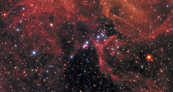 This new image of the supernova remnant SN 1987A was taken by the NASA/ESA Hubble Space Telescope in January 2017 using its Wide Field Camera 3 (WFC3). Since its launch in 1990 Hubble has observed the expanding dust cloud of SN 1987A several times and this way helped astronomers to create a better understanding of these cosmic explosions. Supernova 1987A is located in the centre of the image amidst a backdrop of stars. The bright ring around the central region of the exploded star is composed of material ejected by the star about 20 000 years before the actual explosion took place. The supernova is surrounded by gaseous clouds. The clouds’ red colour represents the glow of hydrogen gas. The colours of the foreground and background stars were added from observations taken by Hubble’s Wide Field Planetary Camera 2 (WFPC2).
