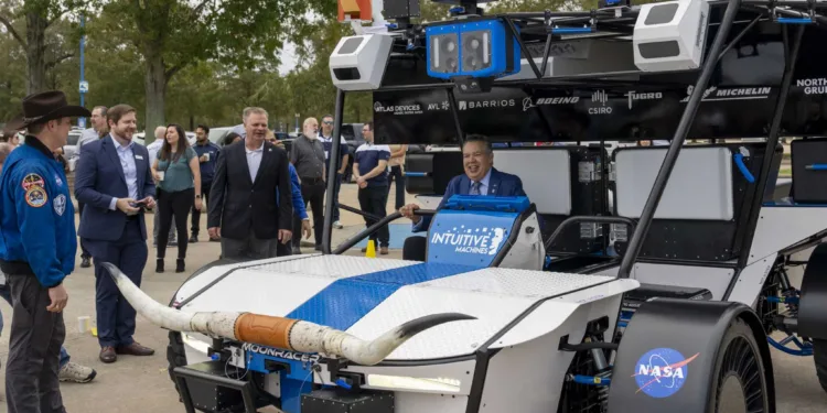 Intuitive Machines Senior Vice President of Space Systems Trent Martin, left center, stands near as Space Center Houston President and CEO William Harris, right, smiles as he sits in the seat of the Intuitive Machines Moonracer Lunar Terrain Vehicle (LTV) during a reveal of the vehicle Thursday, Nov. 7, 2024 in Houston.