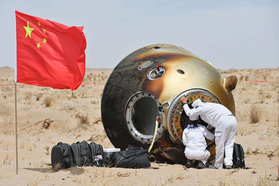 Personal de rescate inspecciona una cápsula de reentrada del programa espacial Shenzhou tras el aterrizaje en Mongolia Interior, China.