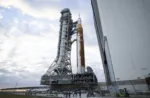 El cohete del Sistema de Lanzamiento Espacial (SLS) Artemis II de la NASA y la nave espacial Orion, asegurados a la plataforma móvil, se observan mientras realizan el viaje de 4,2 millas hacia la Plataforma de Lanzamiento 39B, el sábado. Crédito de la foto: (NASA/Keegan Barber)