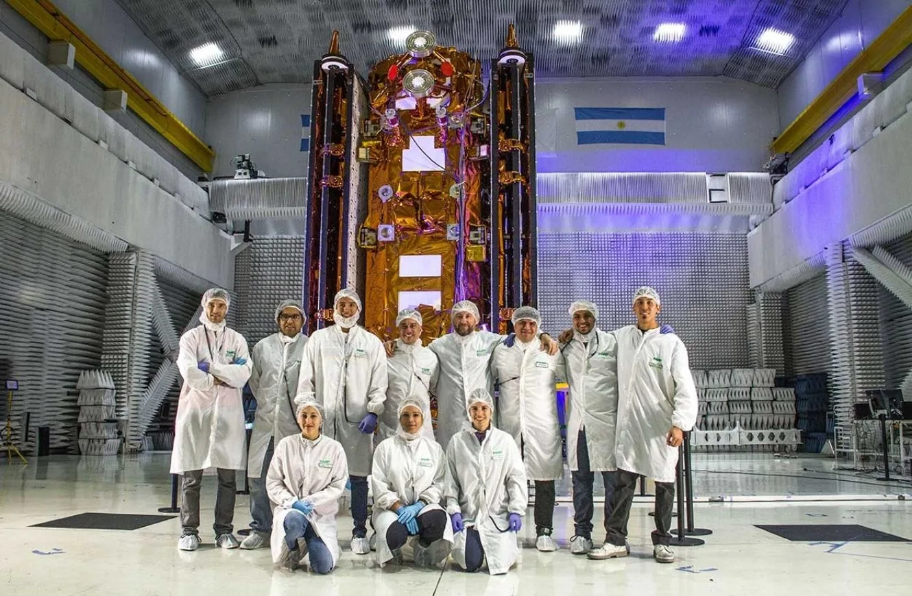 Profesionales de INVAP junto con el satélite SAOCOM, con sus antenas plegadas.