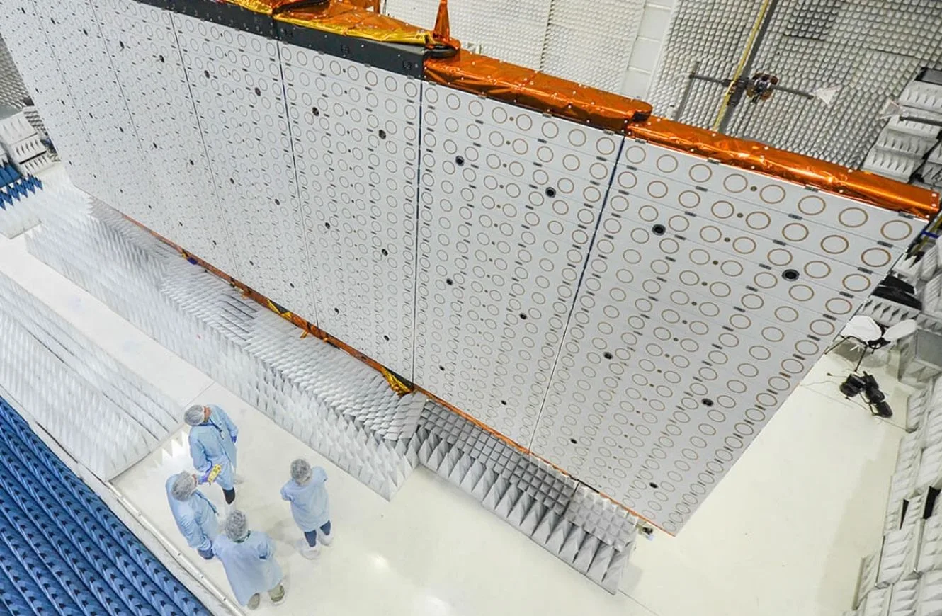 Profesionales de INVAP junto a uno de los paneles o antenas del satélite SAOCOM. Los círculos dorados son los elementos radiantes que transmiten las señales del radar.