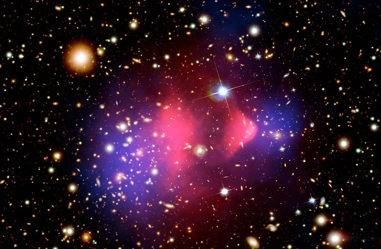 Imagen del Cúmulo Bala. La materia normal se muestra en rosa en el cúmulo, mientras que la lente gravitacional revela materia oscura en el cúmulo mostrado en azul. Esta observación ha proporcionado uno de los ejemplos directos más claros de materia oscura.