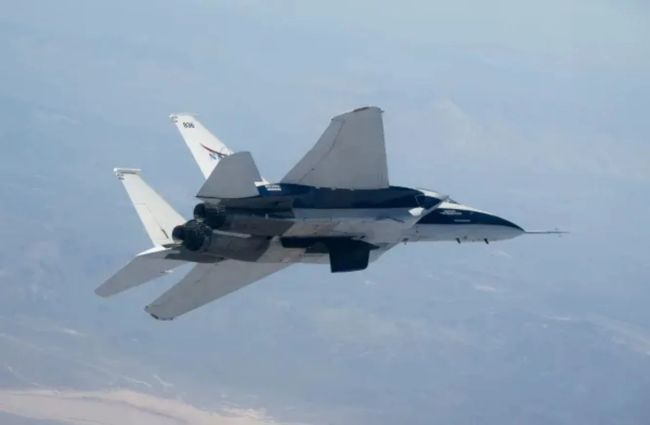 El modelo a escala del ala del Flujo Laminar Natural Atenuado por Flujo Cruzado (CATNLF) de la NASA vuela en un avión de investigación F-15 de la NASA.