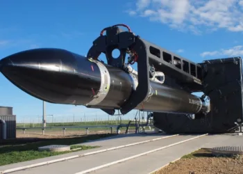 Un cohete Electron en posición horizontal, montado en un banco de integración/ensayo antes de su traslado a la rampa. Es el caballo de batalla de carga pequeña de Rocket Lab que consolidó su operación de lanzamientos frecuentes.