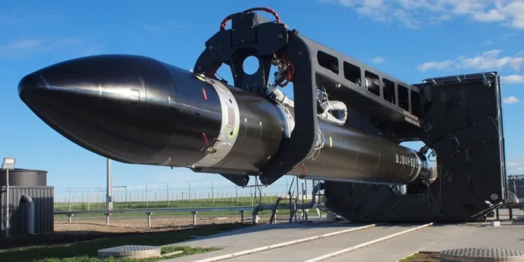 Un cohete Electron en posición horizontal, montado en un banco de integración/ensayo antes de su traslado a la rampa. Es el caballo de batalla de carga pequeña de Rocket Lab que consolidó su operación de lanzamientos frecuentes.