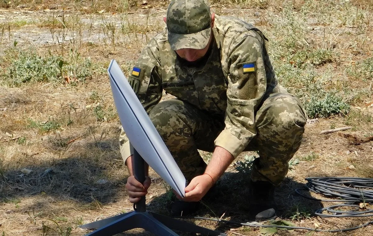 Un soldado ucraniano ajusta una terminal Starlink, portátil y para conectividad satelital en órbita baja (LEO).