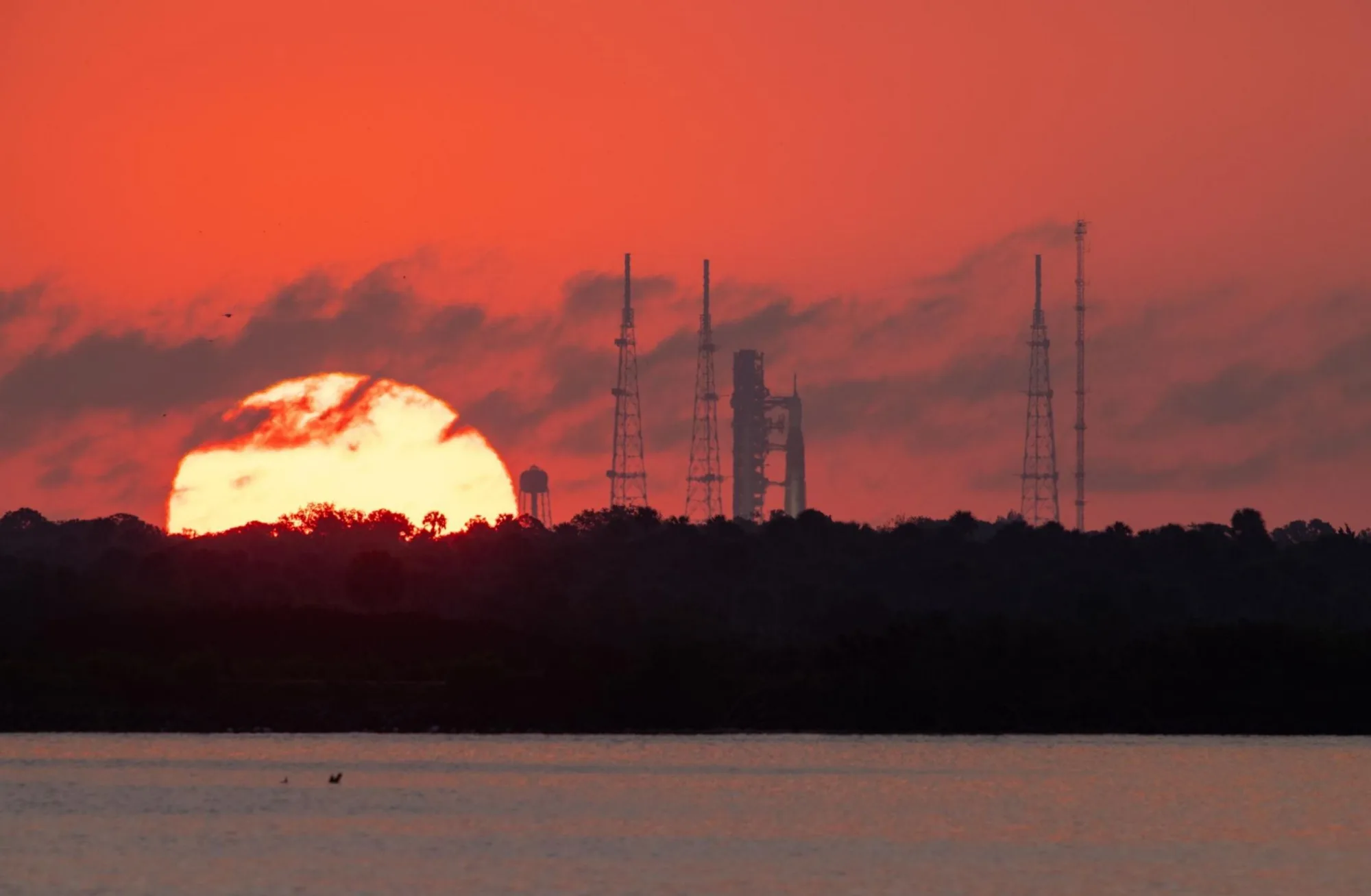 El sol sale detrás del cohete Space Launch System (SLS) de la NASA en el Complejo de Lanzamiento 39B del Centro Espacial Kennedy.
