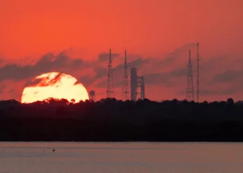 El sol sale detrás del cohete Space Launch System (SLS) de la NASA en el Complejo de Lanzamiento 39B del Centro Espacial Kennedy.