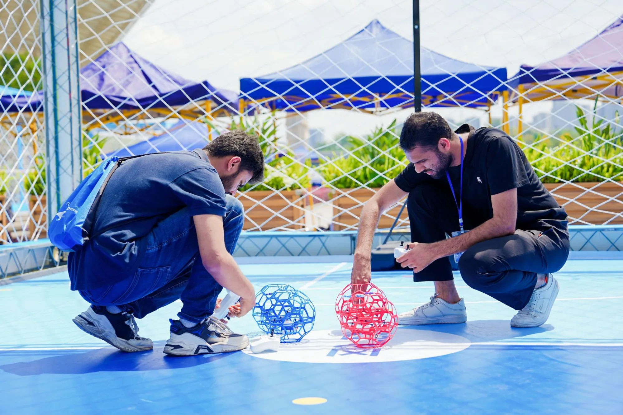Dos jóvenes se preparan para competir en los primeros Juegos Mundiales de drones, disputados en China.