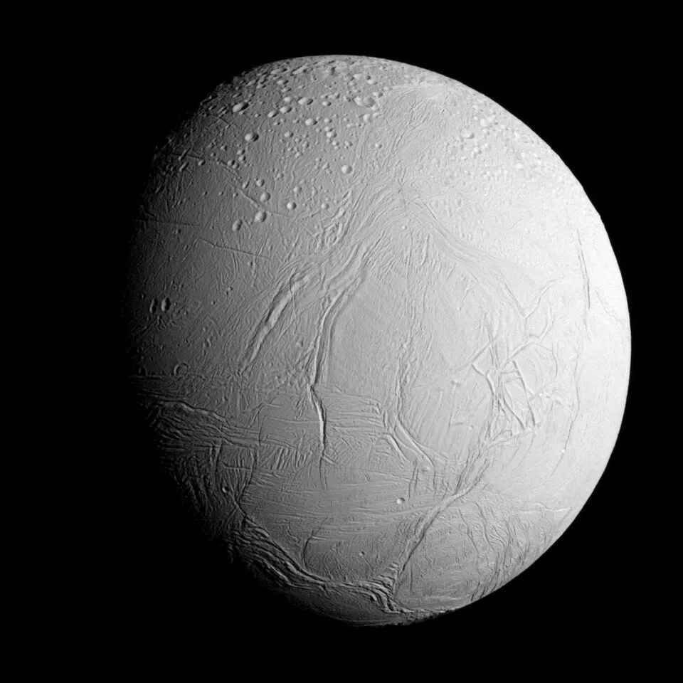 Encelado es una de las lunas de Saturno, que debajo de su corteza de hielo esconde un océano global de agua salada.