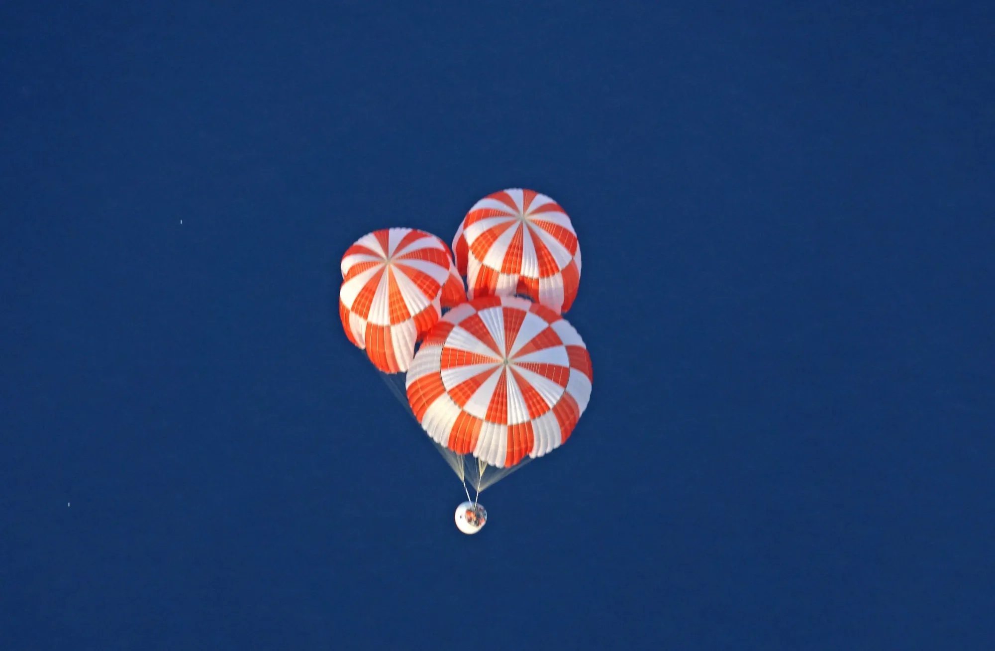 Imagen de la cápsula para la misión tripulada Gaganyaan realizando la segunda prueba integrada de lanzamiento aéreo (IADT-02) tras la apertura de paracaídas para el amerizaje en océano. Crédito: ISRO. Prueba lanzamiento india