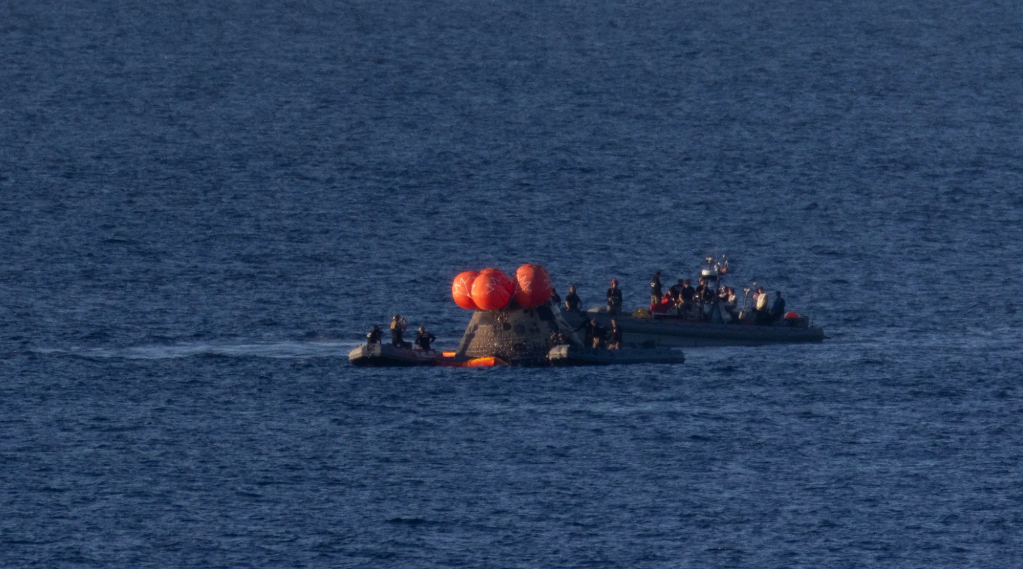 Los equipos de rescate de NASA alrededor de la cápsula Orión, ya en el océano.