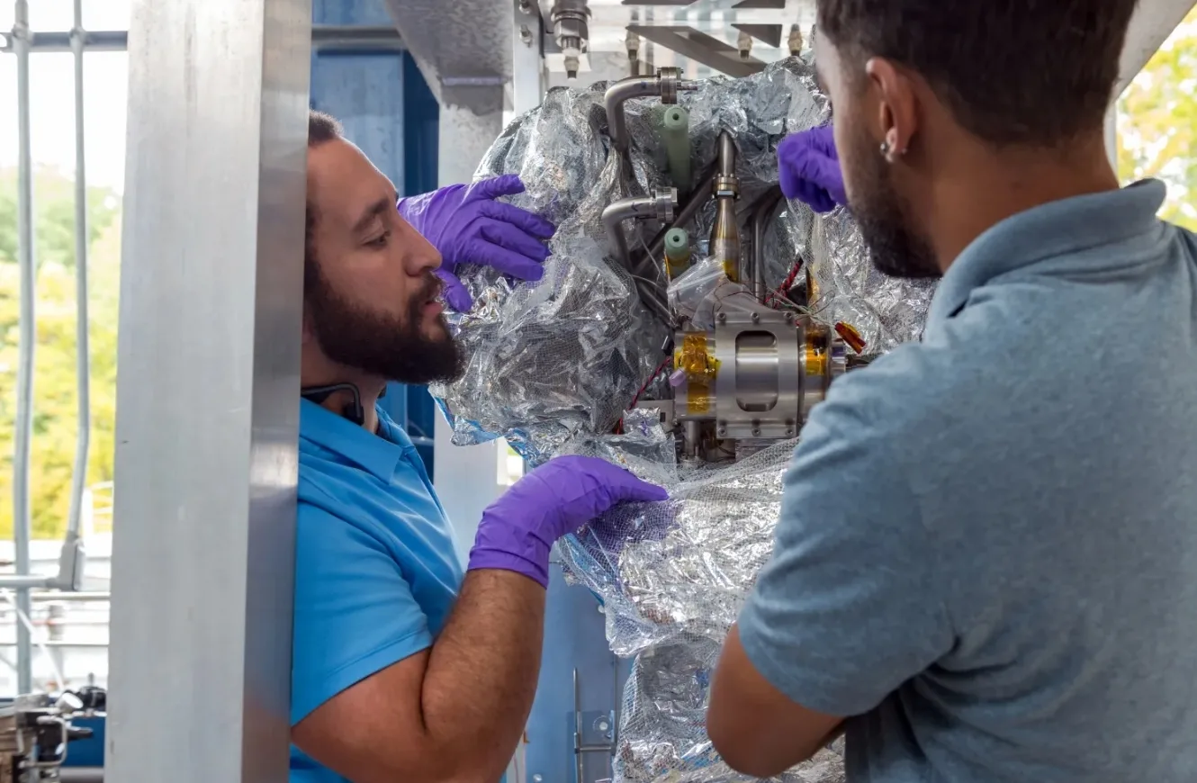 Los ingenieros de la NASA Jonathan Davis (izquierda) y Markus Perkins inspeccionan un criorefrigerador de tipo aeroespacial desarrollado por Creare LLC antes de su integración en el sistema CryoFILL que la NASA está probando. Los ingenieros trabajan dentro del Complejo Criogénico Creek Road del Centro de Investigación Glenn de la NASA. Crédito: NASA. LOXSAT NASA