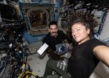 Los astronautas de la NASA Jack Hathaway y Jessica Meir posan juntos mientras Hathaway muestra un par de casetes de investigación del Procesador de Muestras de Experimento Espacial Avanzado-4 que se utilizan para estudiar cómo la ingravidez afecta el crecimiento de cristales de fármacos, lo que posiblemente conduzca a nuevas fórmulas farmacéuticas. Crédito: NASA.