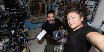 Los astronautas de la NASA Jack Hathaway y Jessica Meir posan juntos mientras Hathaway muestra un par de casetes de investigación del Procesador de Muestras de Experimento Espacial Avanzado-4 que se utilizan para estudiar cómo la ingravidez afecta el crecimiento de cristales de fármacos, lo que posiblemente conduzca a nuevas fórmulas farmacéuticas. Crédito: NASA.