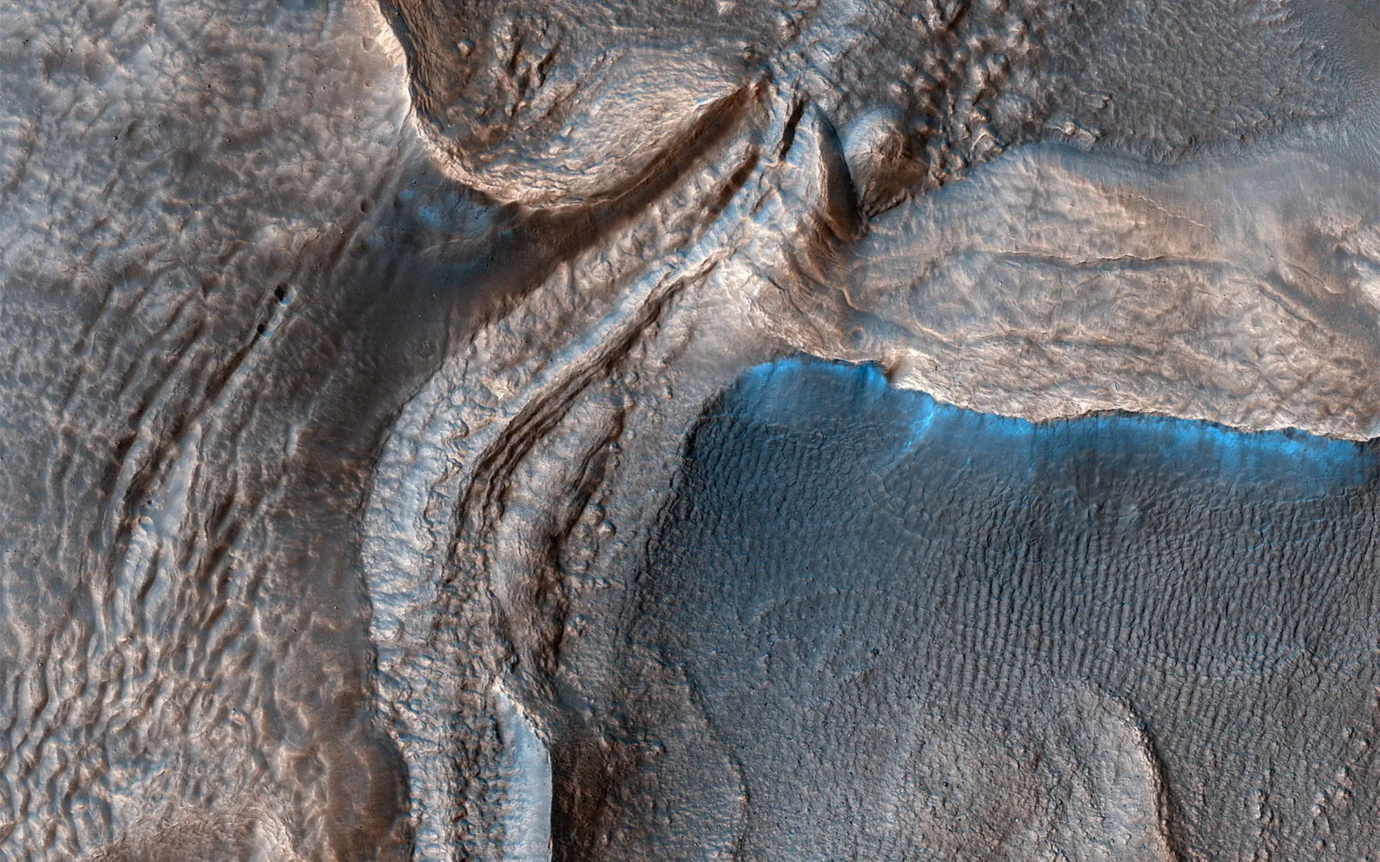 Imagen tomada HiRISE (High Resolution Imaging Experiment) del Orbitador de Reconocimiento de Marte (MRO). Se observa el valle de Harmakhis, un canal de desagüe de 800 kilómetros de longitud ubicado en el este de Hélade. El valle probablemente se formó por una combinación de colapso de la superficie y flujo de agua.