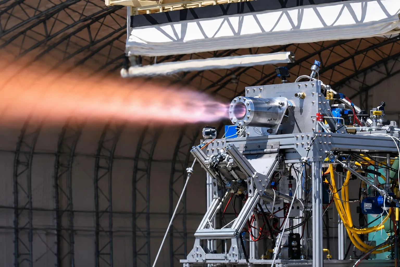 Imagen representativa de una prueba en banco de un motor cohete de combustible líquido de capacidad de empuje similar al Reaction Control Engine (RCE) de Aerojet.