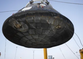 El módulo de tripulación Artemis II Orion luego de la recuperación, siendo elevado para su inspección tras ser descargado del buque de recuperación USS John P. Murtha. Las áreas hundidas, o círculos concéntricos más pequeños están asociadas con los pernos de separación que conectan el módulo de tripulación con el módulo de servicio. Los patrones circulares más grandes se forman debido al material de la almohadilla de compresión, lo que crea perturbaciones en el flujo causadas por el flujo de aire aerodinámico y térmico extremo durante la reentrada. Crédito: NASA/ Kevin Davis.