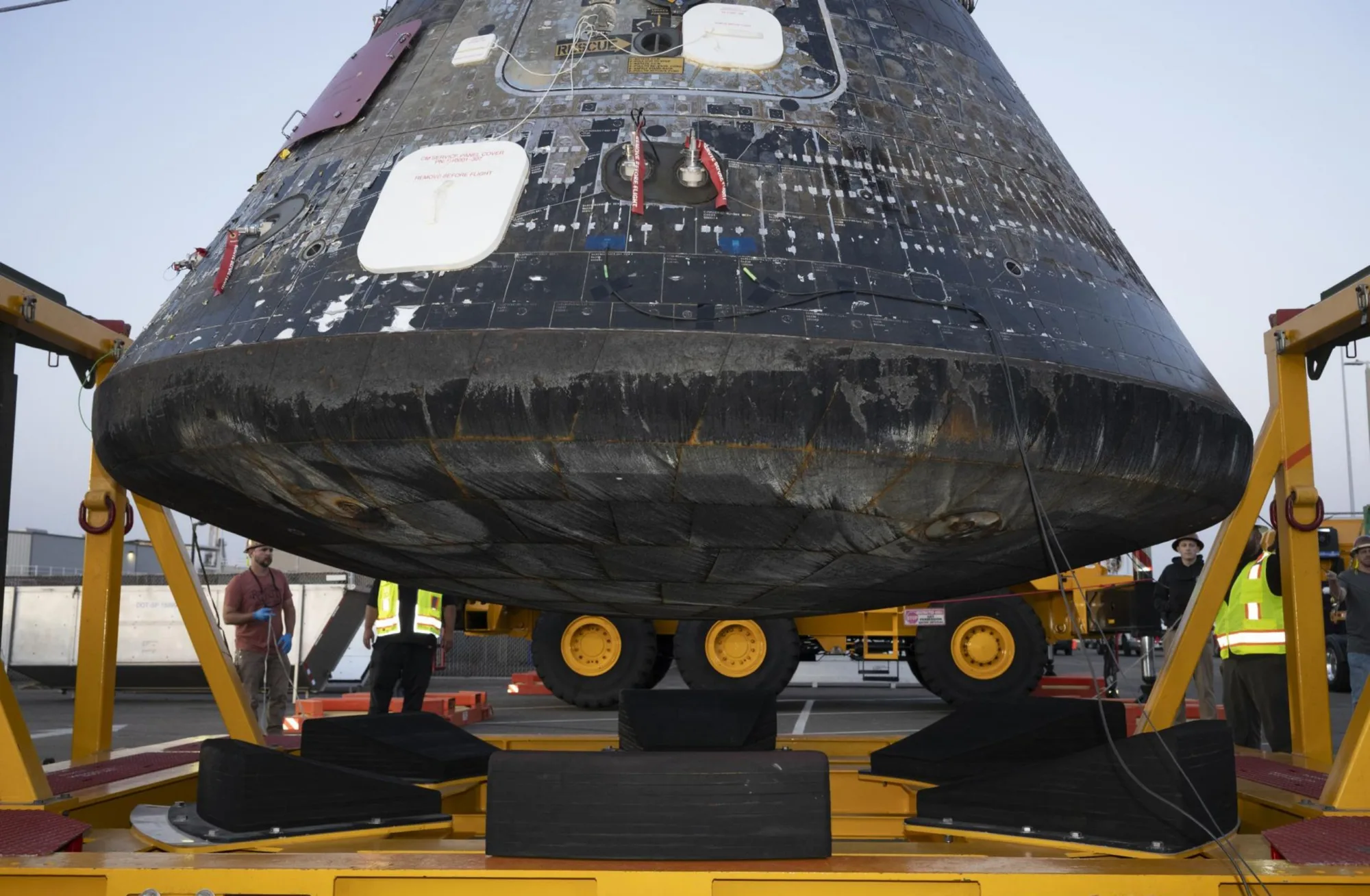 El módulo de tripulación Artemis II Orion luego de la recuperación, siendo elevado para su inspección tras ser descargado del buque de recuperación USS John P. Murtha. Crédito: NASA/ Kevin Davis.