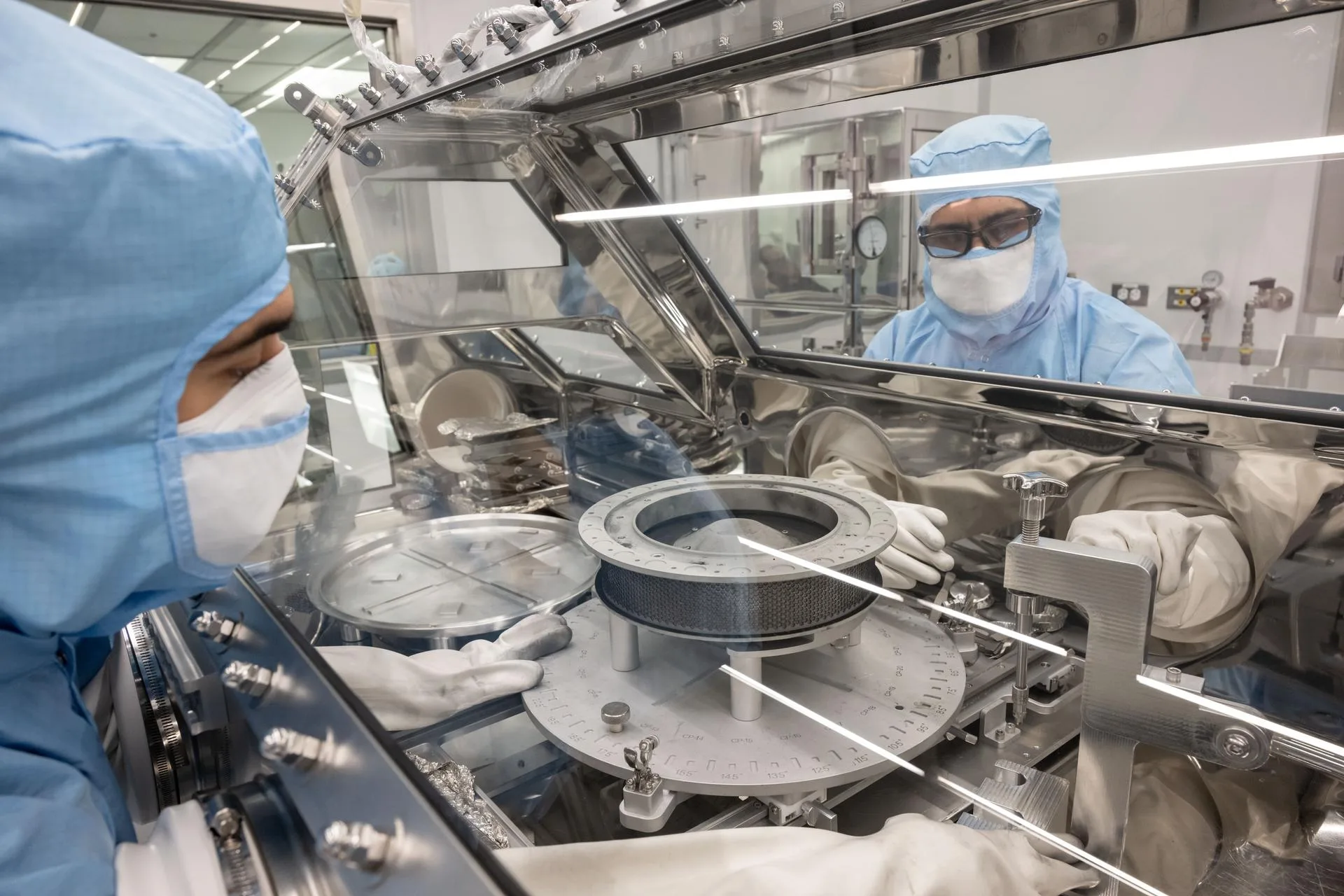 El equipo de conservación de OSIRIS-REx retira los dos sujetadores del cabezal TAGSAM para realizar el curado de las muestras. Crédito: NASA/ Robert Markowitz.